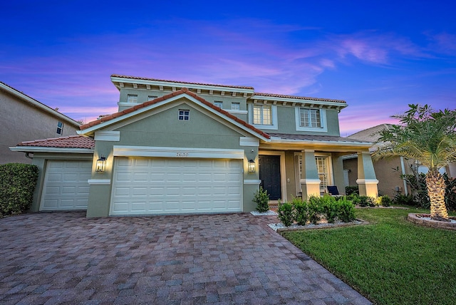 view of front of home with a lawn, a garage, and covered porch