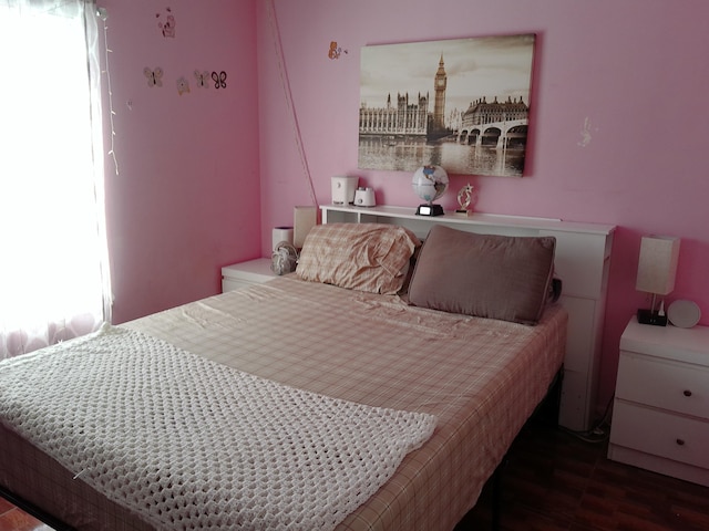 bedroom with multiple windows and hardwood / wood-style flooring