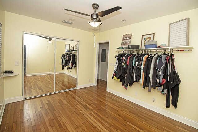 walk in closet featuring wood-type flooring and ceiling fan