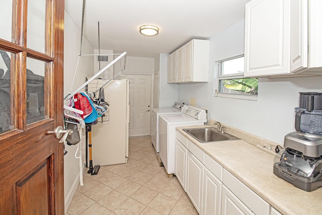 laundry area featuring light tile patterned flooring, washer and clothes dryer, sink, and cabinets