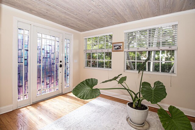 foyer featuring hardwood / wood-style floors, crown molding, and wood ceiling