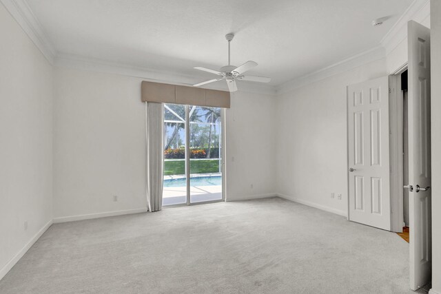 carpeted empty room featuring baseboards, ornamental molding, and ceiling fan