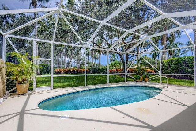 view of pool featuring a lawn, a patio, and a lanai