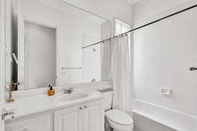 bathroom featuring toilet, shower / bath combination with curtain, and vanity