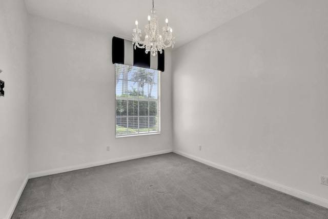 carpeted empty room featuring a notable chandelier