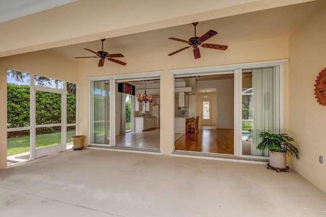 unfurnished sunroom with plenty of natural light and ceiling fan with notable chandelier