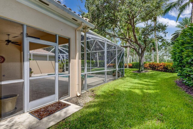 view of yard with glass enclosure, a patio area, and an outdoor pool