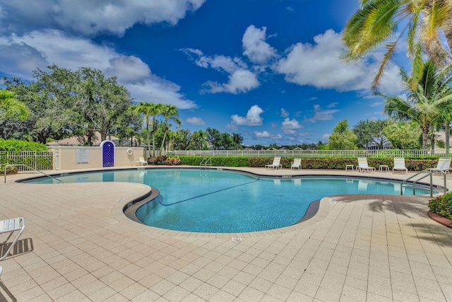 pool with a patio and fence