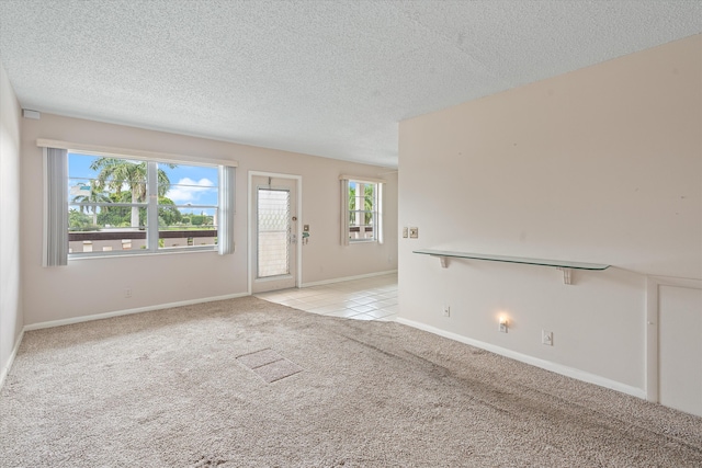 carpeted empty room featuring plenty of natural light and a textured ceiling