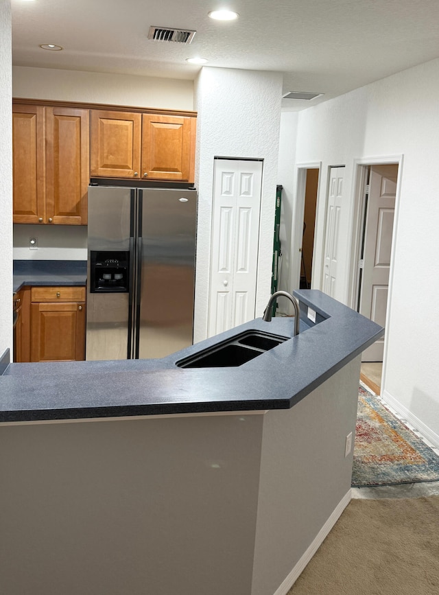 kitchen with stainless steel fridge with ice dispenser, sink, and carpet floors