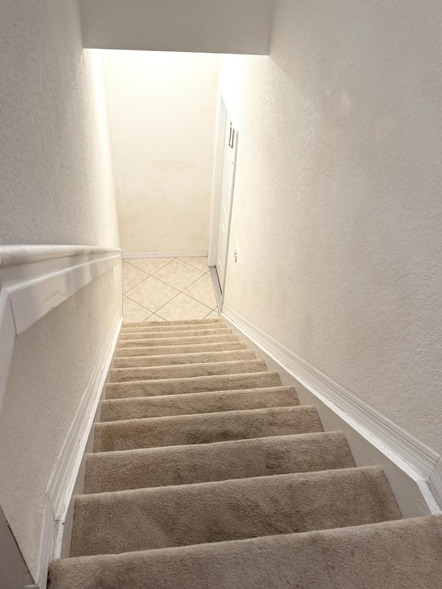 stairs featuring tile patterned floors