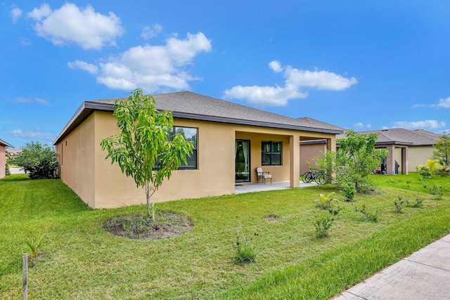 rear view of house featuring a yard and a patio area