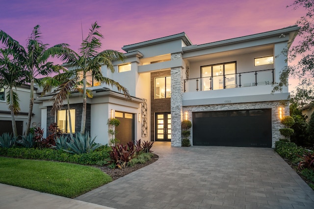 view of front of property featuring a balcony and a garage