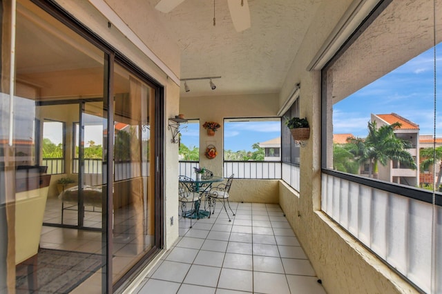 sunroom featuring ceiling fan and rail lighting