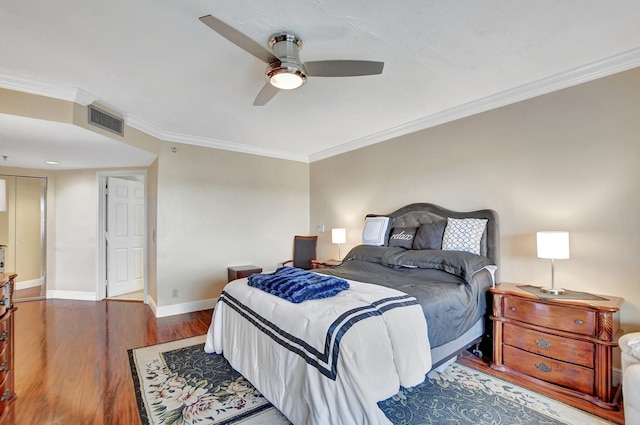 bedroom featuring ceiling fan, ornamental molding, and dark hardwood / wood-style floors