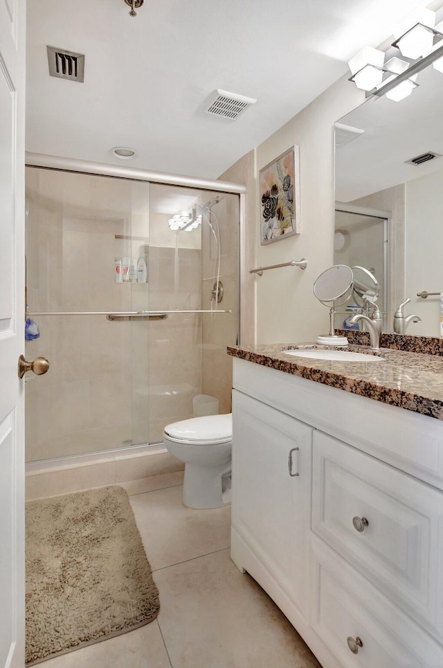 bathroom with tile patterned flooring, toilet, and walk in shower