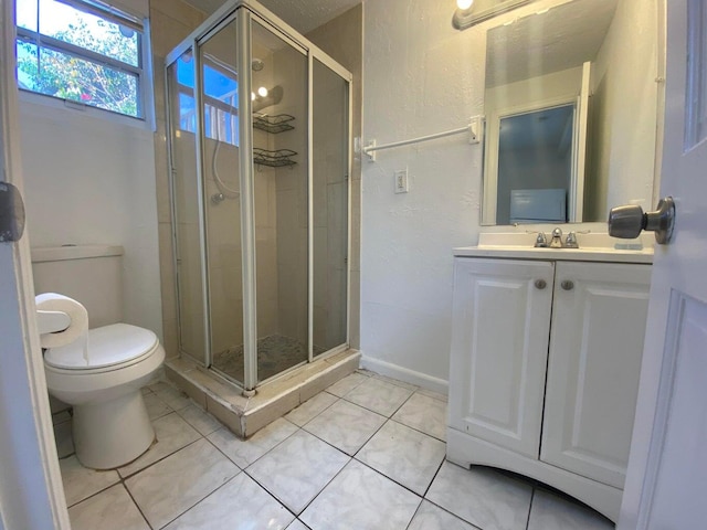 bathroom featuring tile patterned floors, toilet, vanity, and an enclosed shower