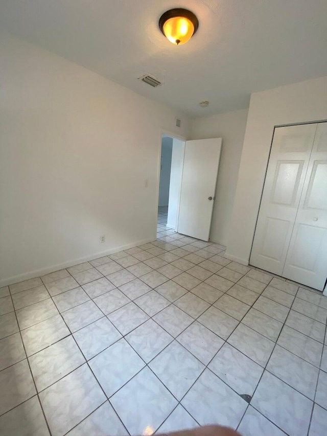 unfurnished bedroom featuring a closet and light tile patterned floors