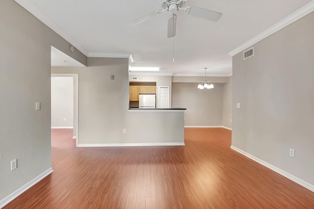 spare room with ornamental molding, ceiling fan with notable chandelier, and hardwood / wood-style floors