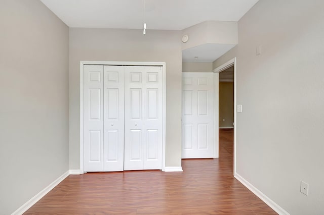 unfurnished bedroom featuring a closet and hardwood / wood-style flooring