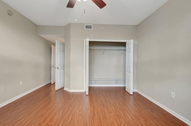 unfurnished bedroom with wood-type flooring, a closet, and ceiling fan