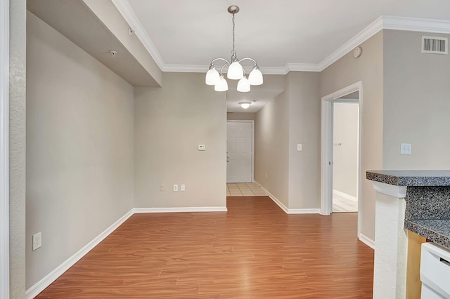 unfurnished dining area with crown molding, hardwood / wood-style flooring, and a chandelier