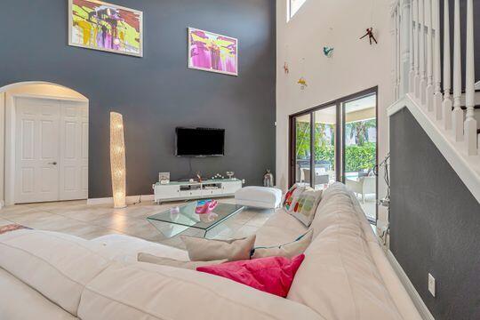 living room with a towering ceiling and light tile patterned floors