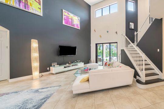 tiled living room with a high ceiling and a wealth of natural light