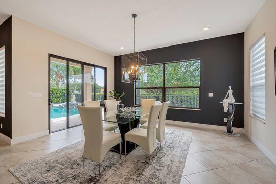 tiled dining room with an inviting chandelier