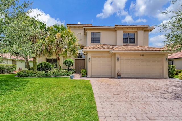 mediterranean / spanish-style home with a front yard and a garage