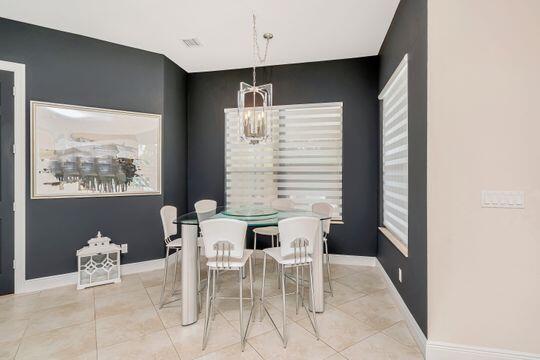 tiled dining area with an inviting chandelier