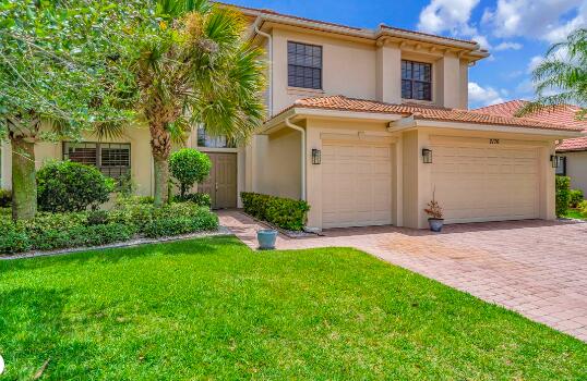 mediterranean / spanish-style home featuring a garage and a front lawn