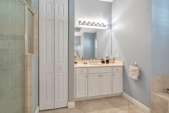 bathroom with walk in shower, tile patterned flooring, and vanity