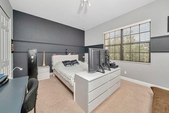 bedroom featuring light colored carpet and a closet