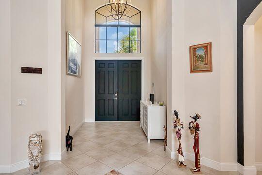 foyer with an inviting chandelier, a towering ceiling, and light tile patterned floors