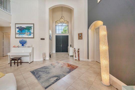 foyer featuring a high ceiling, a chandelier, and light tile patterned floors