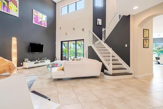 living room featuring light tile patterned flooring, a towering ceiling, and a wealth of natural light