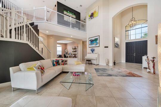 tiled living room with an inviting chandelier and a high ceiling