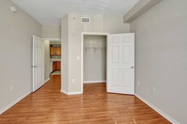 unfurnished bedroom with a closet and light hardwood / wood-style floors