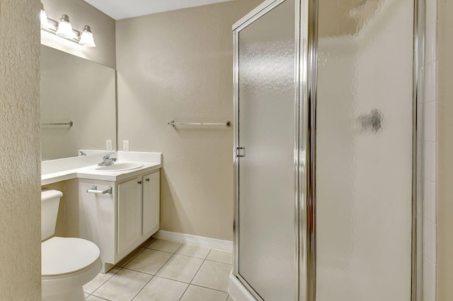 bathroom with a shower with door, vanity, toilet, and tile patterned flooring