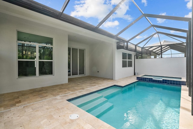 view of swimming pool featuring glass enclosure, a patio area, and a pool with connected hot tub