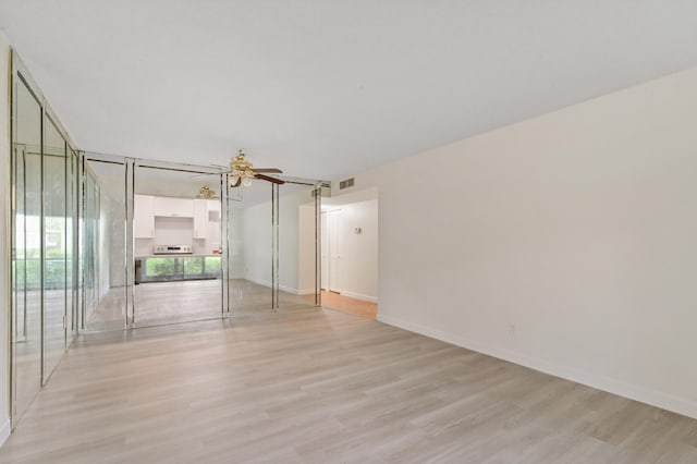 spare room featuring ceiling fan and light hardwood / wood-style floors