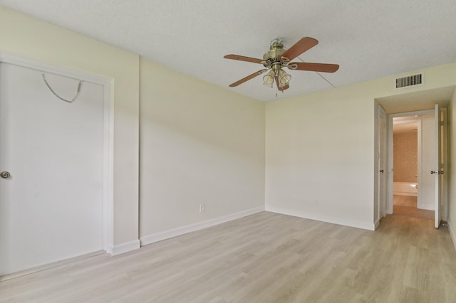 unfurnished room with light wood-type flooring, ceiling fan, and a textured ceiling