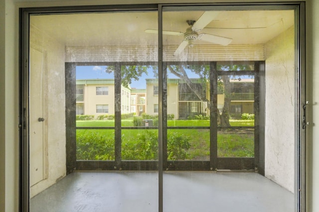 unfurnished sunroom featuring ceiling fan