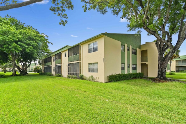 back of property featuring a balcony and a yard