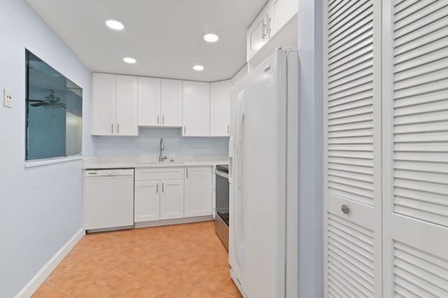 kitchen with sink, white cabinetry, light tile patterned floors, and white appliances