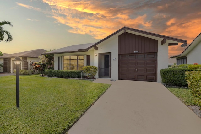 single story home featuring a yard and a garage