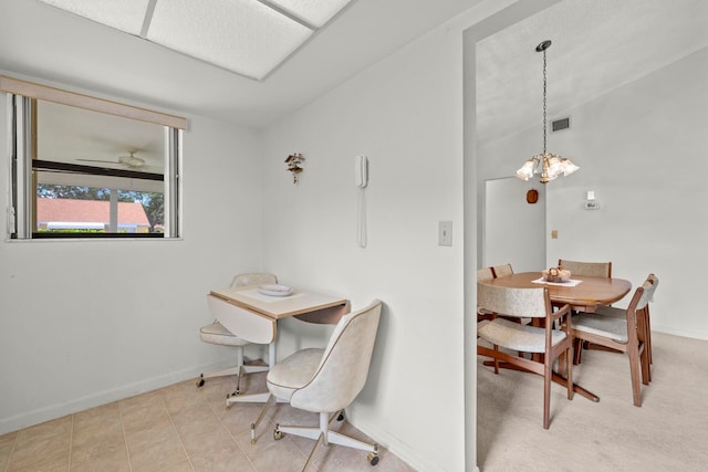 dining area featuring light tile patterned flooring and an inviting chandelier