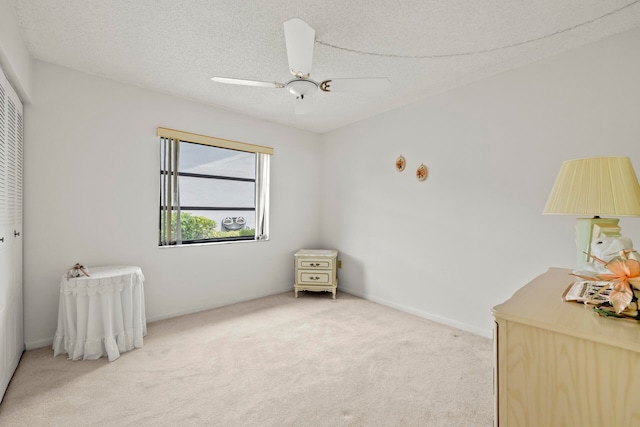 carpeted bedroom featuring ceiling fan, a textured ceiling, and a closet