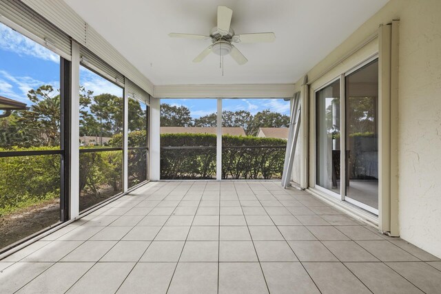 unfurnished sunroom with ceiling fan